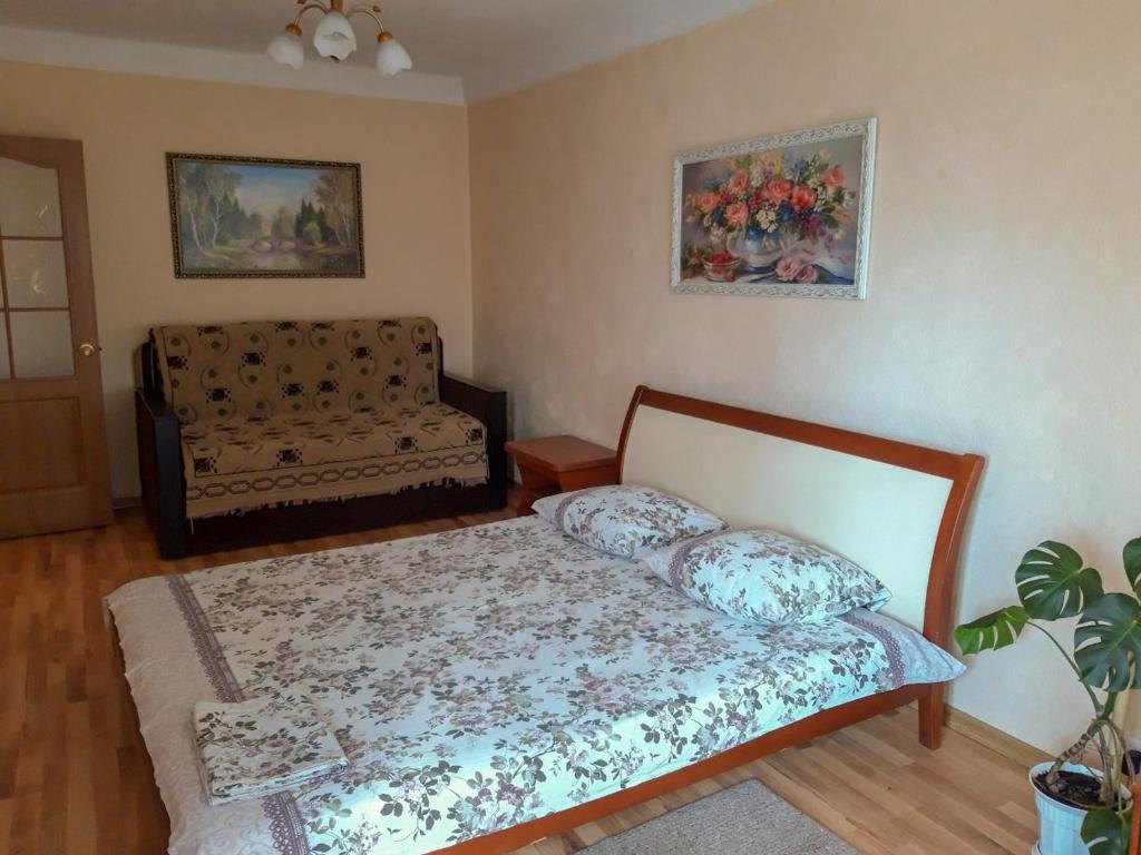 ein Wohnzimmer mit einem Bett und einem Sofa in der Unterkunft Apartment on Livoberezna metro station in Kiew