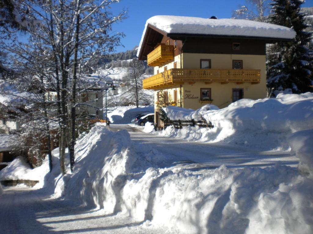 a house covered in snow with a pile of snow at Haus Holzer in Wagrain