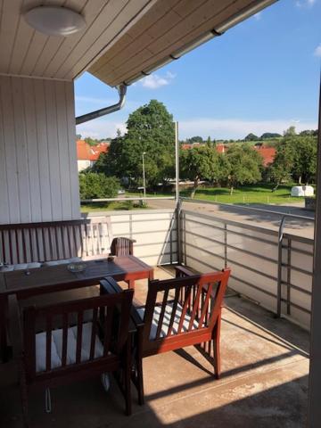 um alpendre com dois bancos e uma mesa e uma mesa e cadeiras em Ferienwohnung Albblick 3 Münsingen em Münsingen