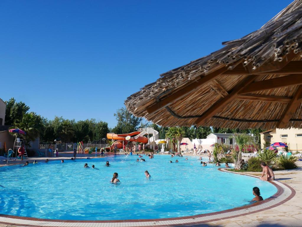 un grupo de personas en una piscina en un complejo en Camping Officiel Siblu Les Sables du Midi, en Valras-Plage