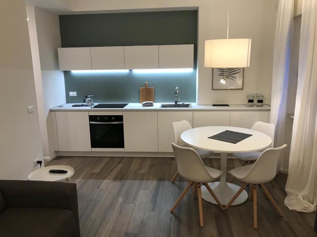 uma cozinha com uma mesa branca e cadeiras num quarto em Casa Daria em Comano Terme