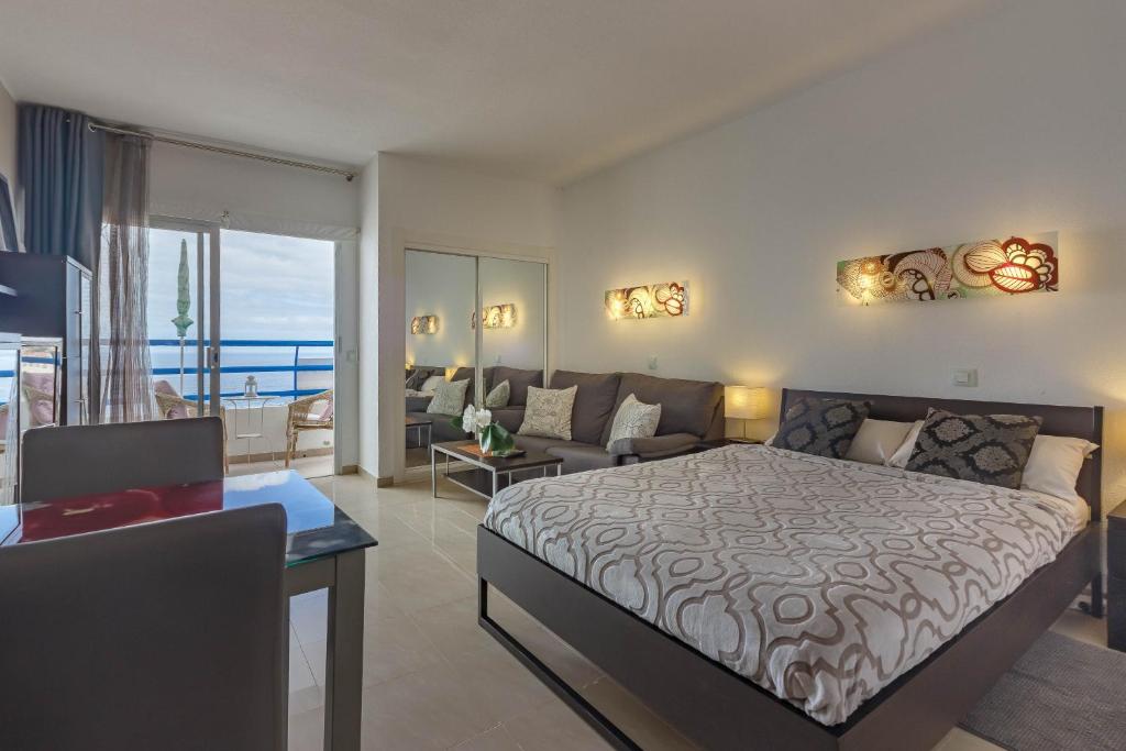 プラヤ・パライソにあるAdeje300, Playa Paraísoのベッドルーム1室(ベッド1台付)、リビングルームが備わります。