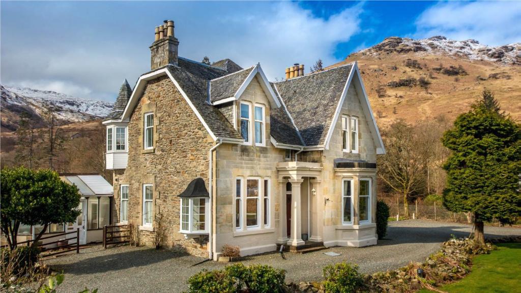 una casa con una montaña al fondo en Rhumhor House, en Carrick