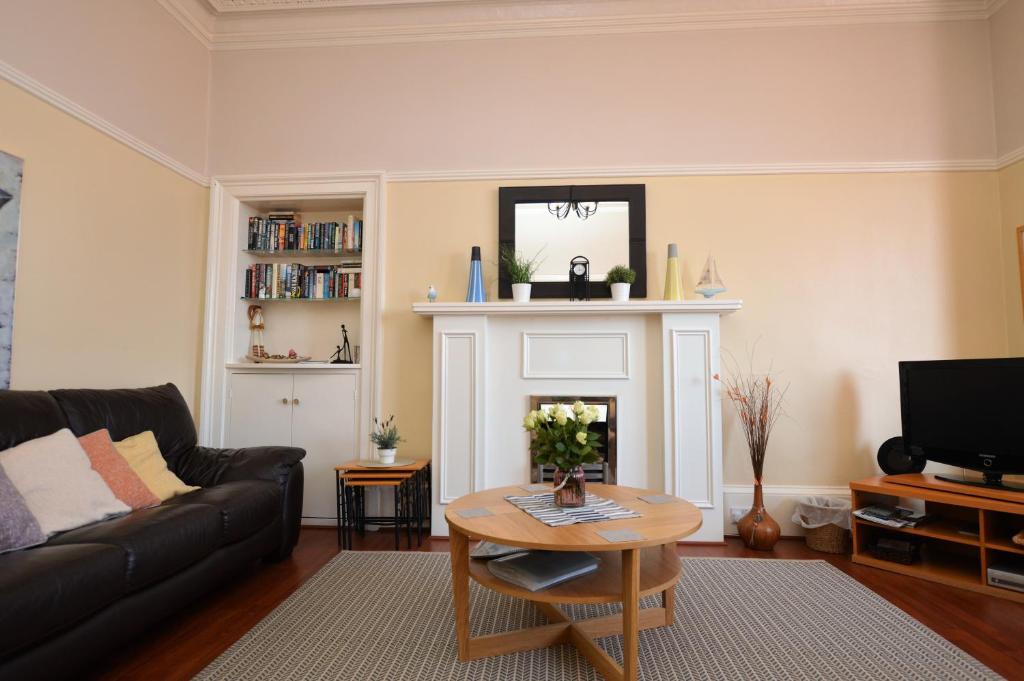 a living room with a couch and a fireplace at Sebright Holiday Apartment in Dunoon