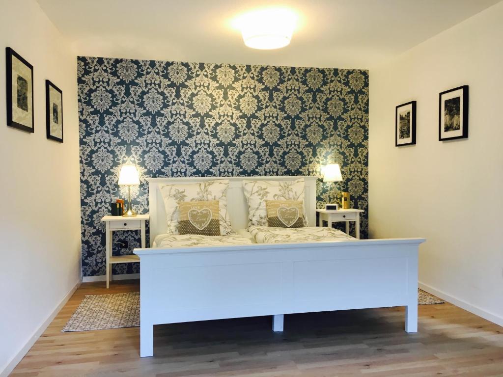 a bedroom with a white bed in a room at Gästehaus Sellemols Ferienwohnung Tabakbauer in Heuchelheim-Klingen