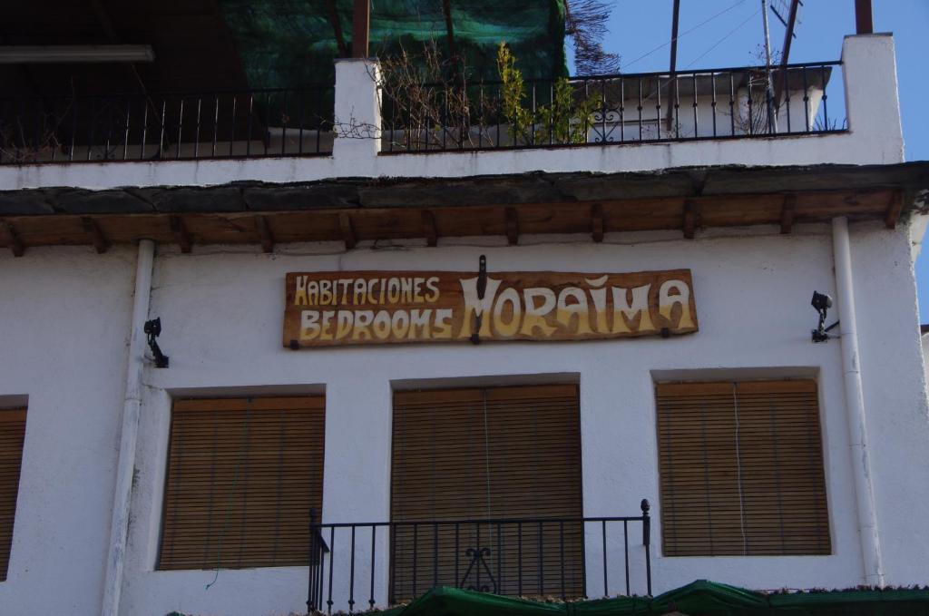 um sinal na lateral de um edifício em Hostal Moraima em Capileira