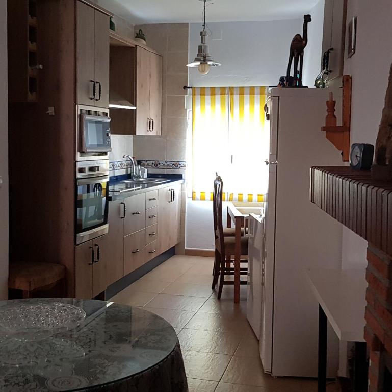 eine kleine Küche mit einem Tisch und einem Fenster in der Unterkunft Alojamiento Rural Jacinta in Torres de Albanchez