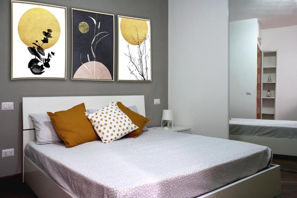 a bedroom with a bed with four paintings on the wall at Da Zia Lù in Tivoli