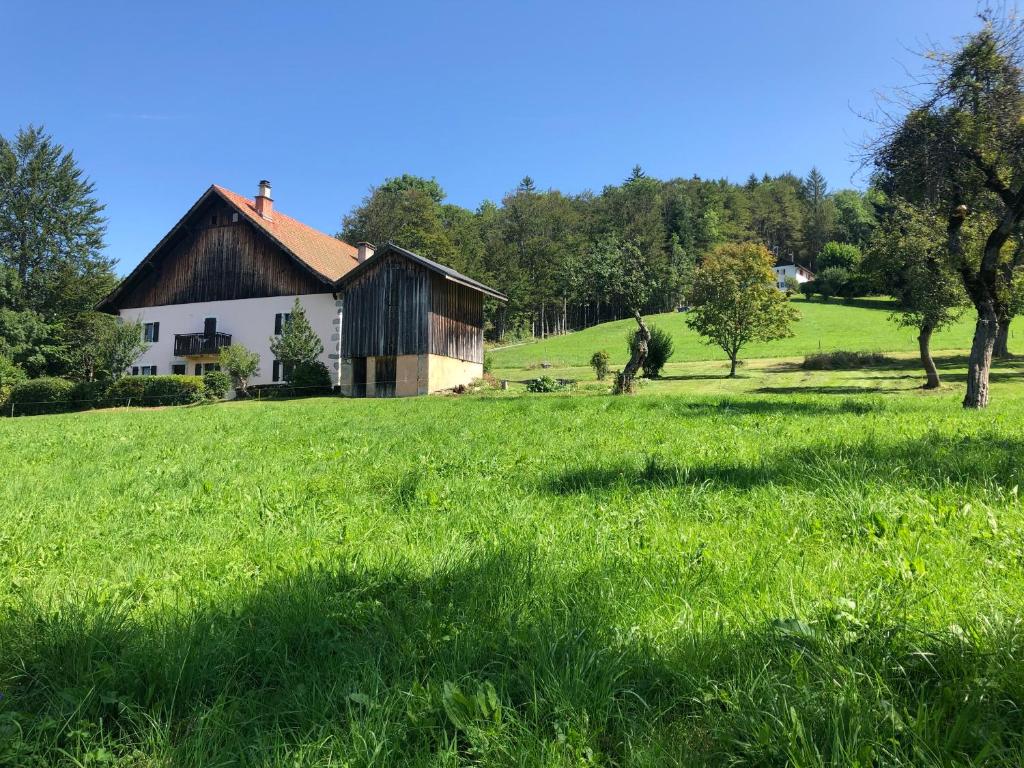 un campo de césped verde con una casa en el fondo en L'ÉPERVIER BLANC en Habère-Poche