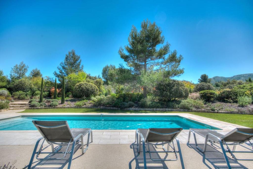 a patio with chairs and a swimming pool at Mas Santoline in Eygalières