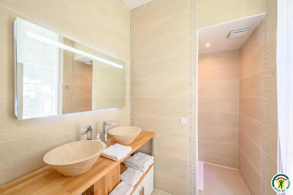 a bathroom with two sinks and a mirror at B&amp;B Au bois dormant chambres d hotes in Tillé