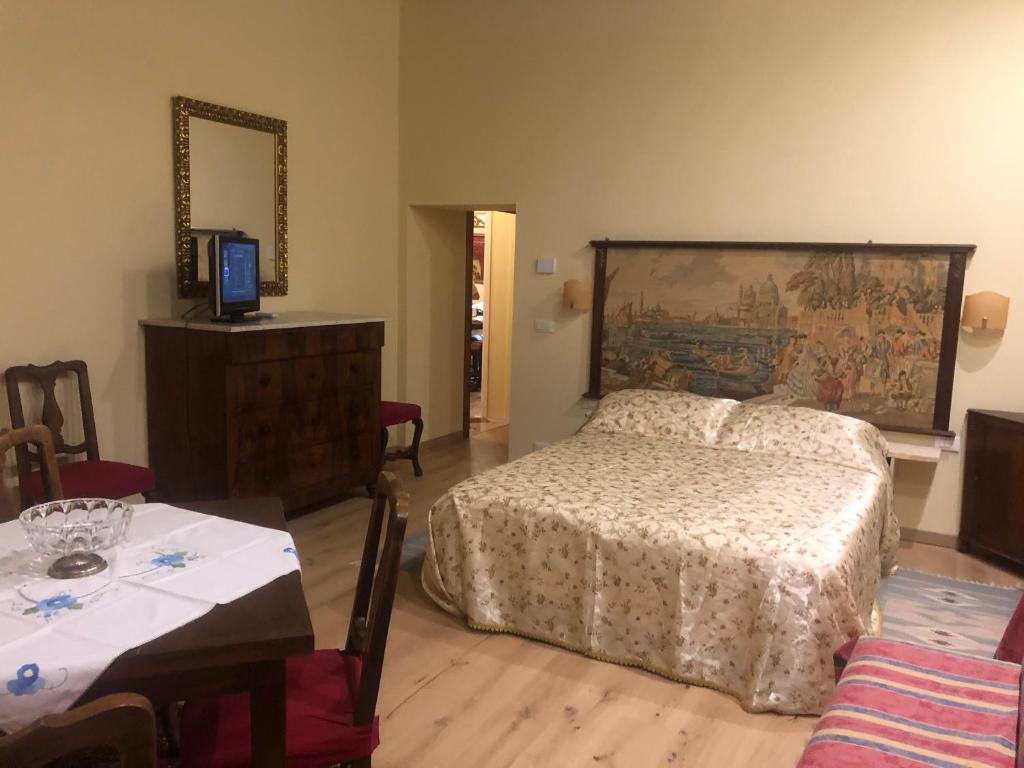een slaapkamer met een bed, een tafel en een spiegel bij La Capannaccia - Venice in Venetië