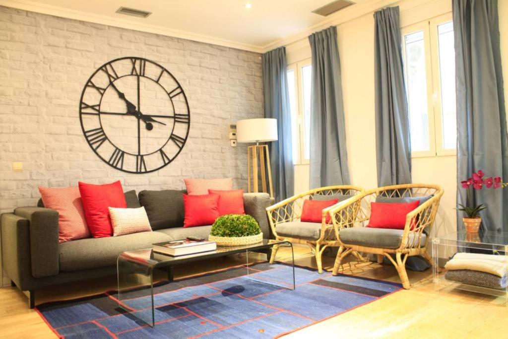 - un salon avec une grande horloge murale dans l'établissement Luxury Apartment in Plaza de España, à Madrid