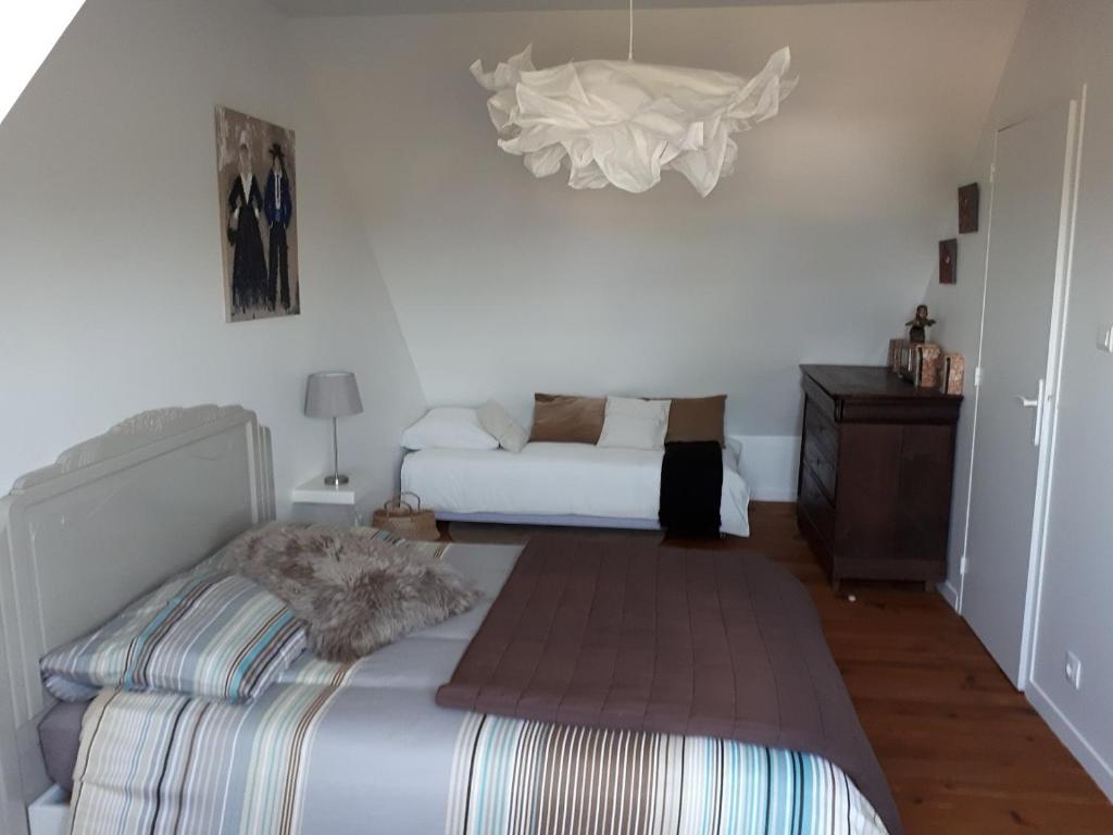 a bedroom with a bed and a couch in it at Charmante maison vue mer in Lestraouen