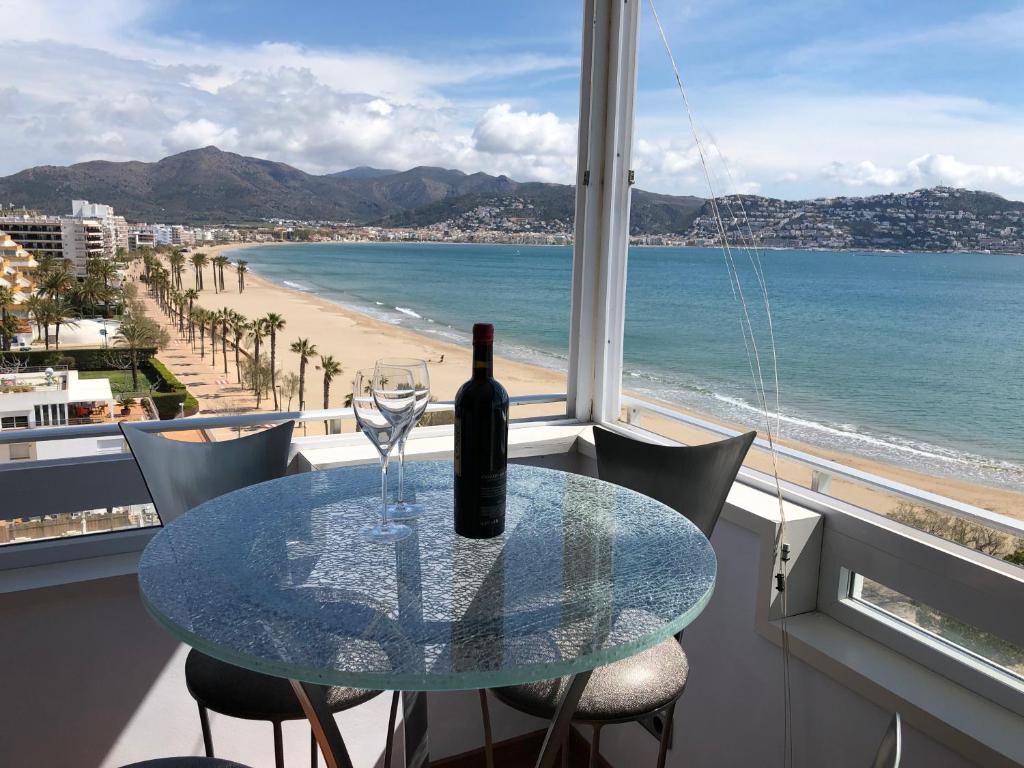 einen Tisch mit einer Flasche Wein und einem Glas in der Unterkunft ROSAS Vue sur Mer in Roses