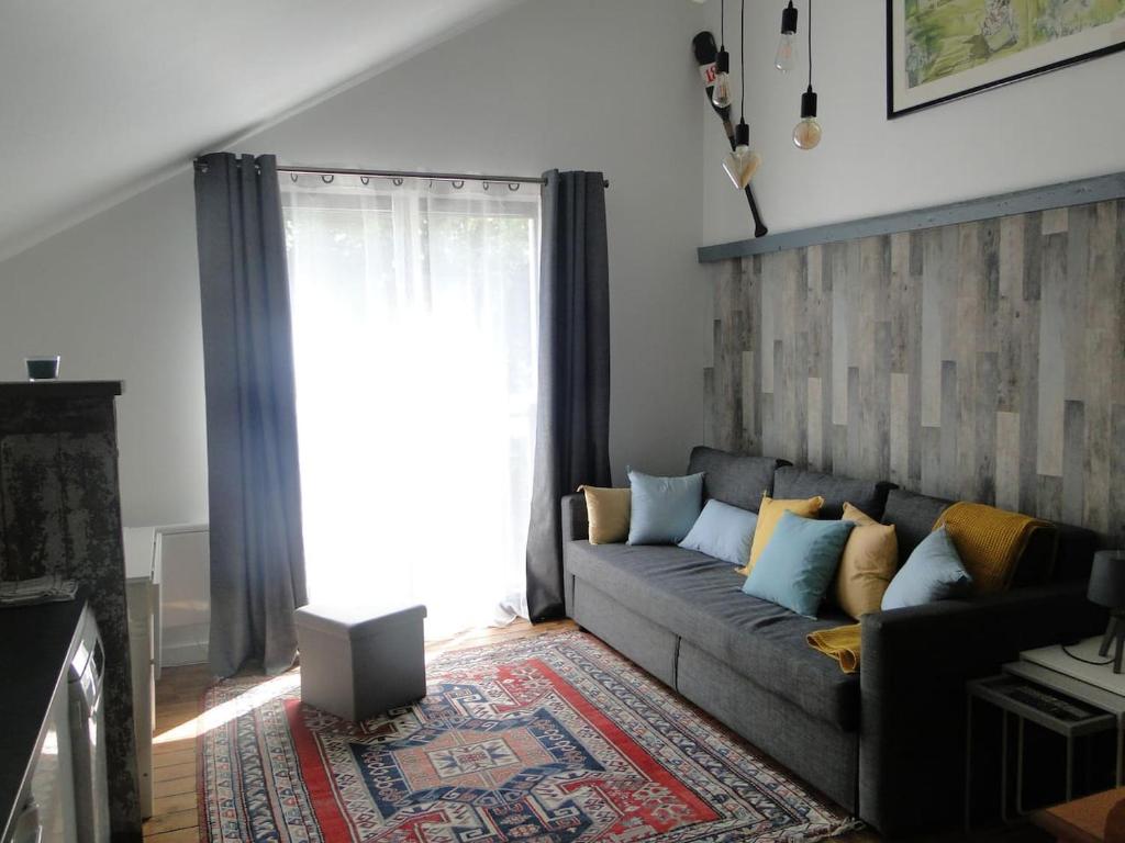 uma sala de estar com um sofá e uma janela em Le Cotin em Fécamp
