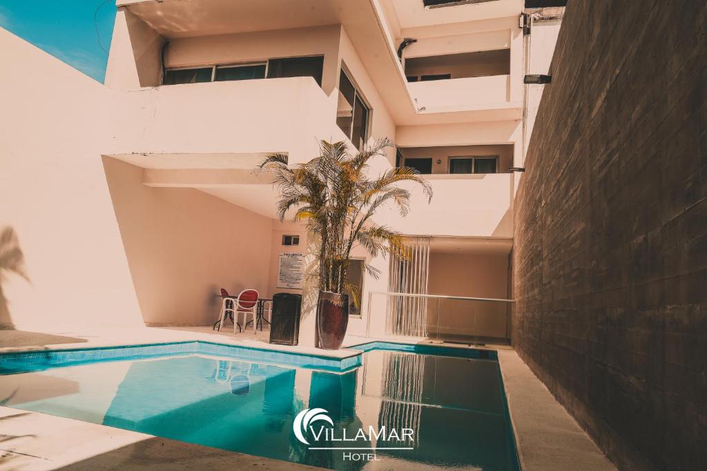 een zwembad voor een gebouw bij Hotel Villamar in Veracruz