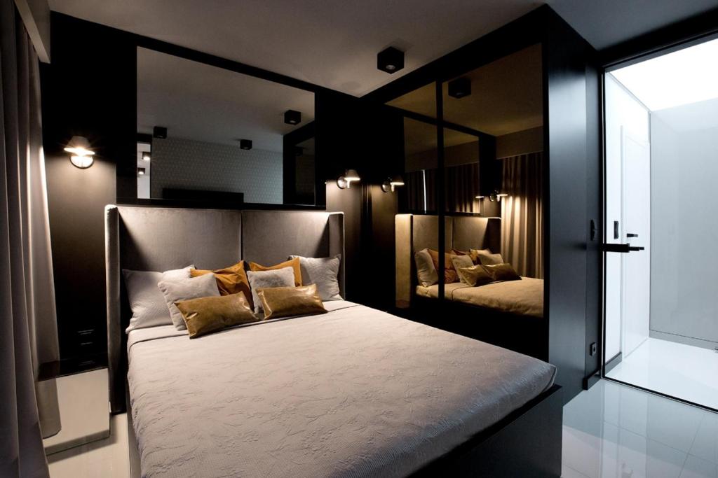 1 dormitorio con 1 cama grande y espejo grande en Super-Apartamenty Andersia VIP en Poznan