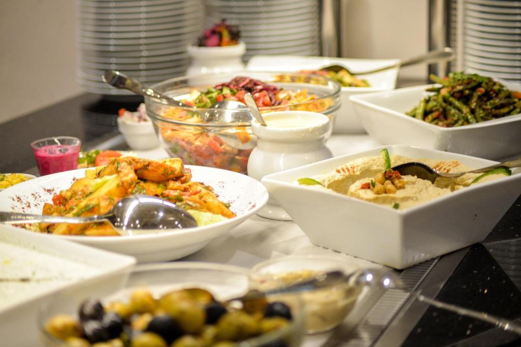 a table with plates of food and bowls of food at Tolip El Narges in Cairo