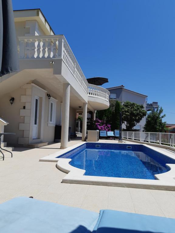 eine Villa mit einem Pool vor einem Haus in der Unterkunft Villa Lizzi in Trogir