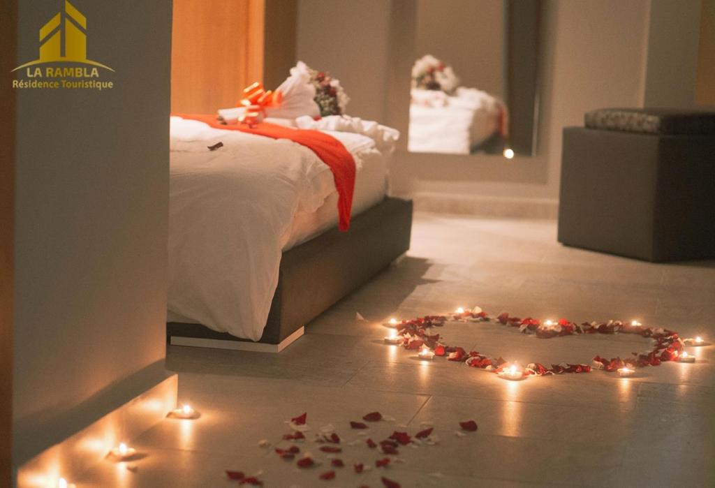 1 dormitorio con un corazón hecho de luces en el suelo en Residence Touristique La Rambla, en Fnidek