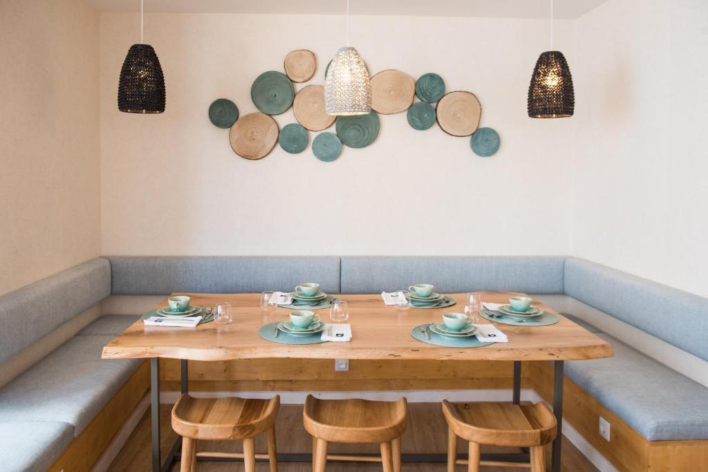 a wooden table with chairs and plates on it at Reserva FLH Hotels Ericeira in Ericeira