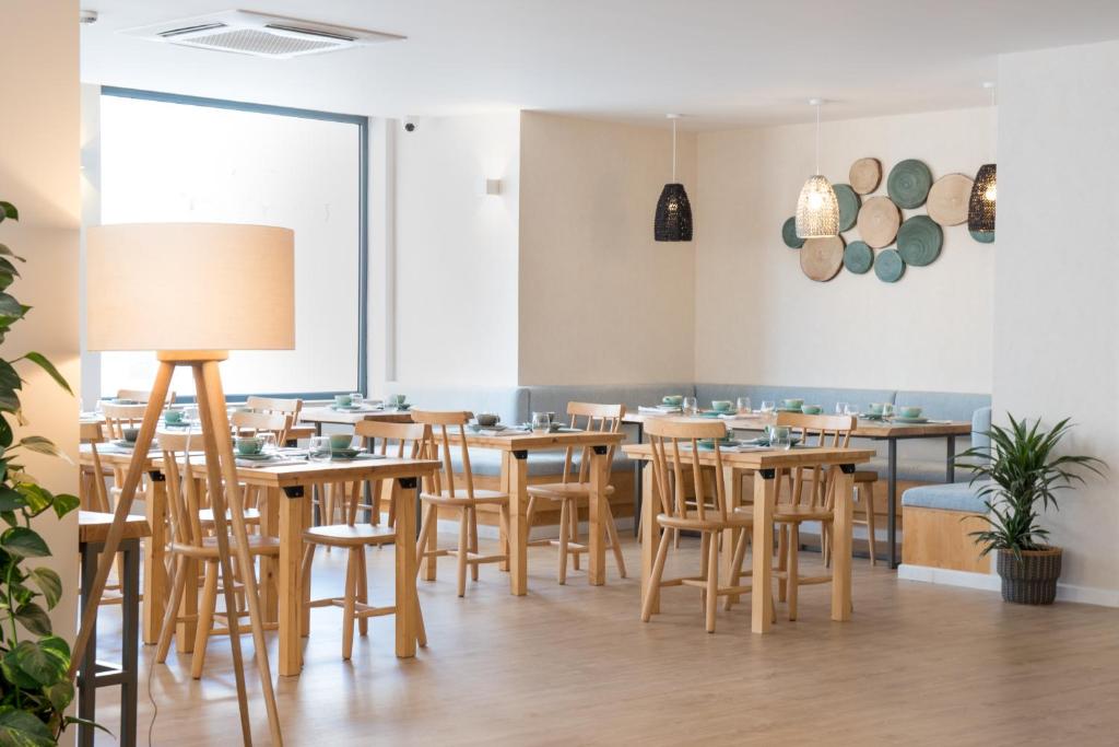 a dining room with wooden tables and chairs at Reserva FLH Hotels Ericeira in Ericeira