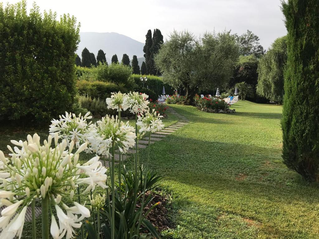 a garden with white flowers and trees at Villa Del Papa in Lucca