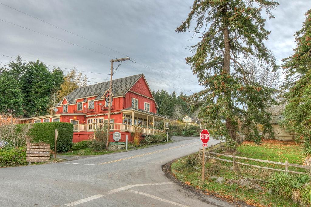 uma casa vermelha numa rua com um sinal de stop em Kingfish at West Sound em Eastsound