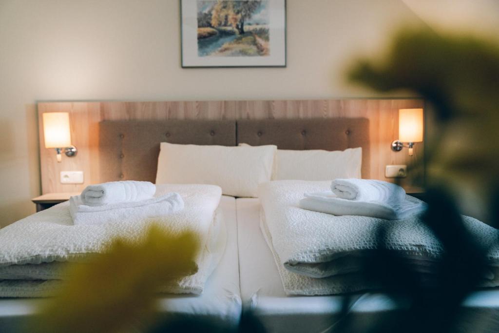 a bedroom with a bed with towels on it at Adelheid Hotel garni in Quedlinburg