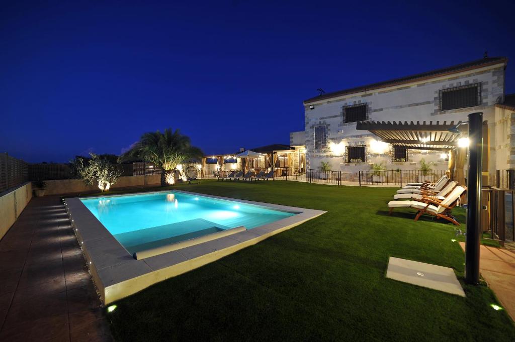 a backyard with a swimming pool at night at Casa Rural Alma Del Tajo, Toledo, Puy Du Fou in Albarreal de Tajo
