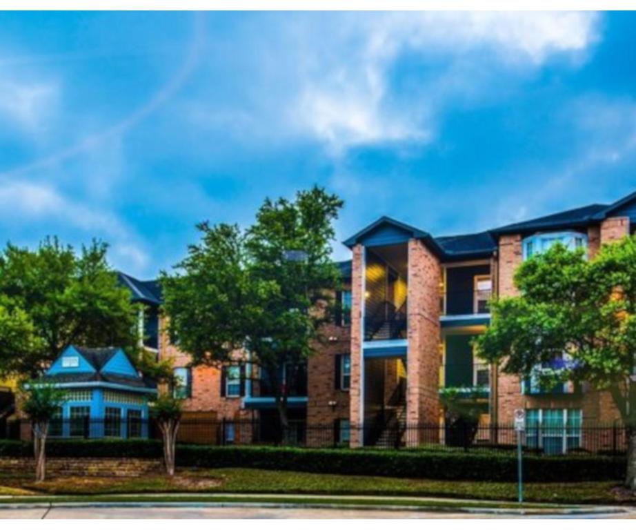 a large brick building with trees in front of it at The Reside Fully Furnished Condos - Medical Stays Welcome in Houston