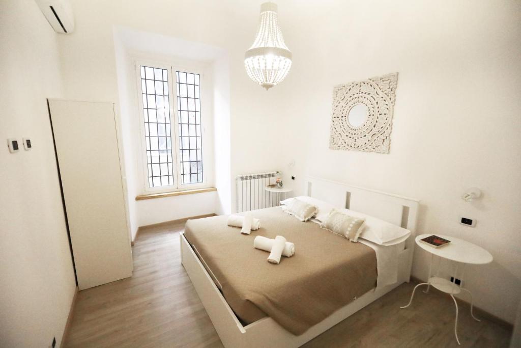 - une chambre blanche avec un lit et un lustre dans l'établissement Appartamento vicino Stazione Termini e Colosseo, à Rome