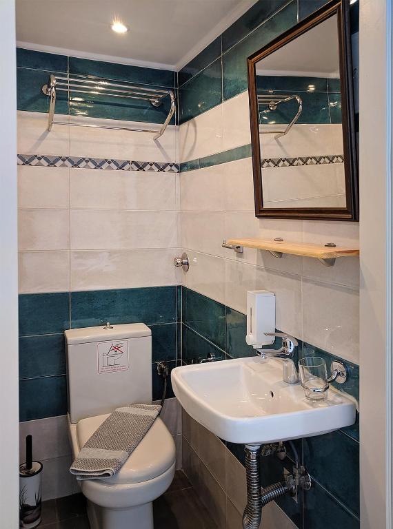 a bathroom with a sink and a toilet and a mirror at Coral in Frangokastello