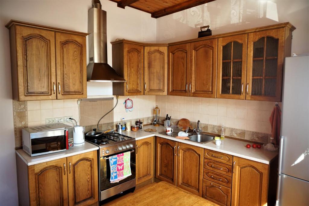 a kitchen with wooden cabinets and a stove top oven at Котедж Гірський in Yaremche