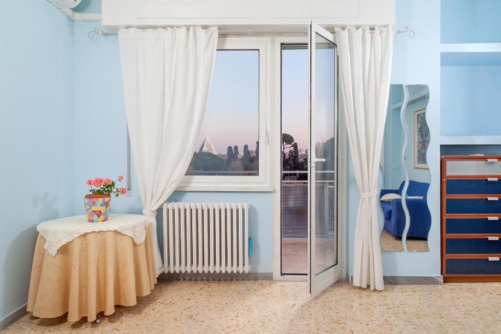 A Casa A Testaccio في روما: غرفة بها نافذة وطاولة عليها زهور