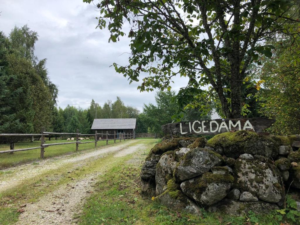 um sinal que lê Litzlandma ao lado de uma estrada de terra em Ligedama Wabatalu em Koljaku