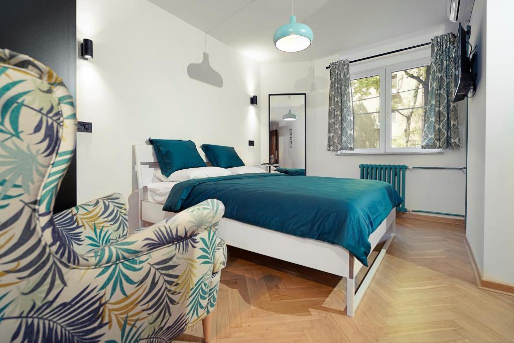a bedroom with a bed and a chair at Tulum Apart Belgrade in Belgrade