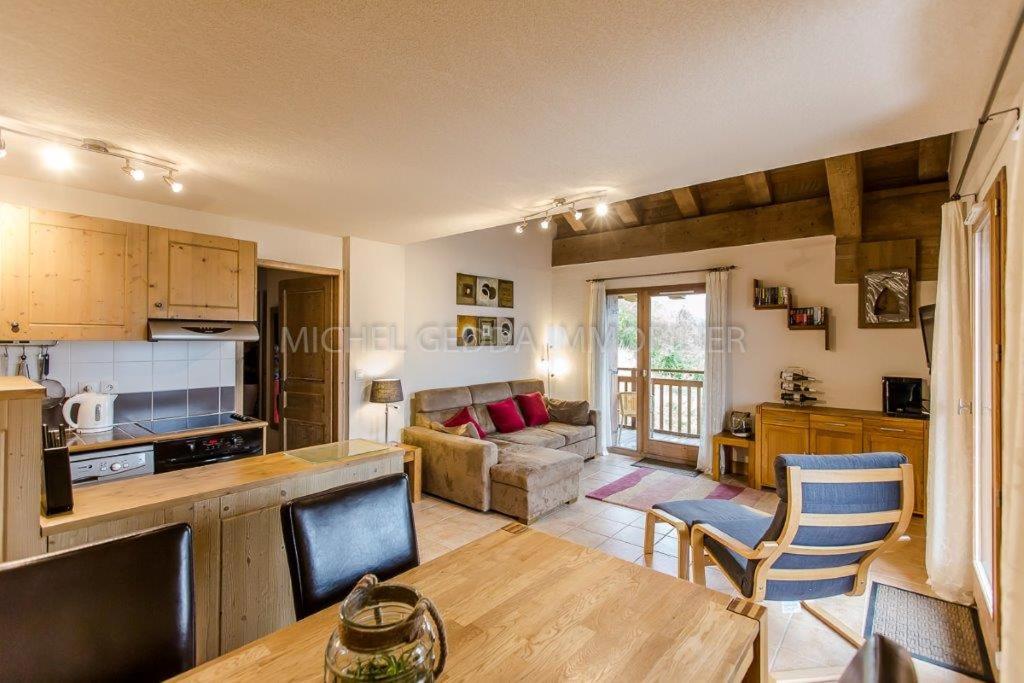 a kitchen and living room with a table and chairs at Les Chalets de Wengen - La Panoramique in Les Coches