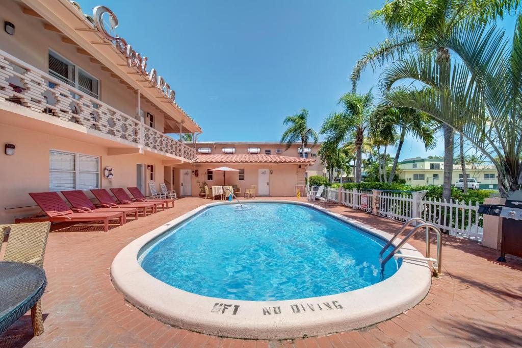 a swimming pool in front of a house with palm trees at The Swan in Hollywood