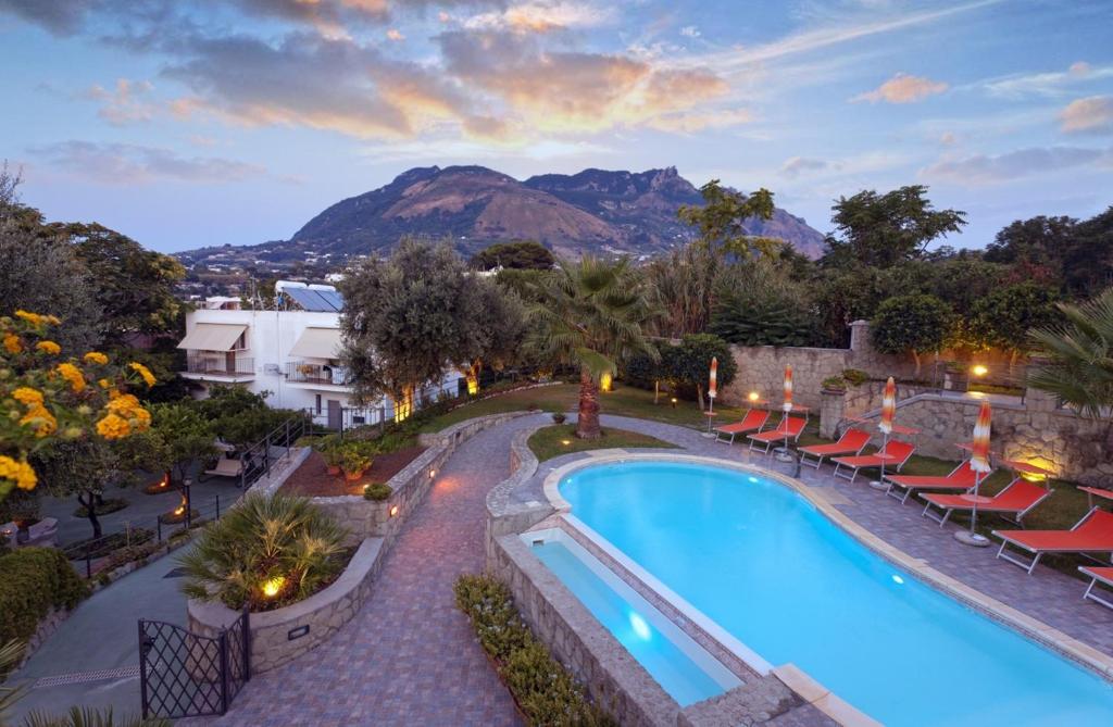vista sulla piscina di un resort con sedie di Casa Vacanze Parco Del Generale a Ischia