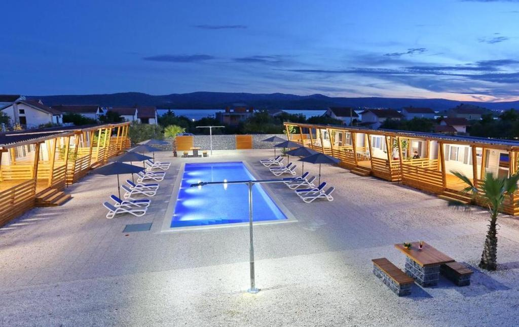 um resort com piscina e espreguiçadeiras em Mobile Homes Dalmacija Turanj Robert''s & Helen''s em Turanj