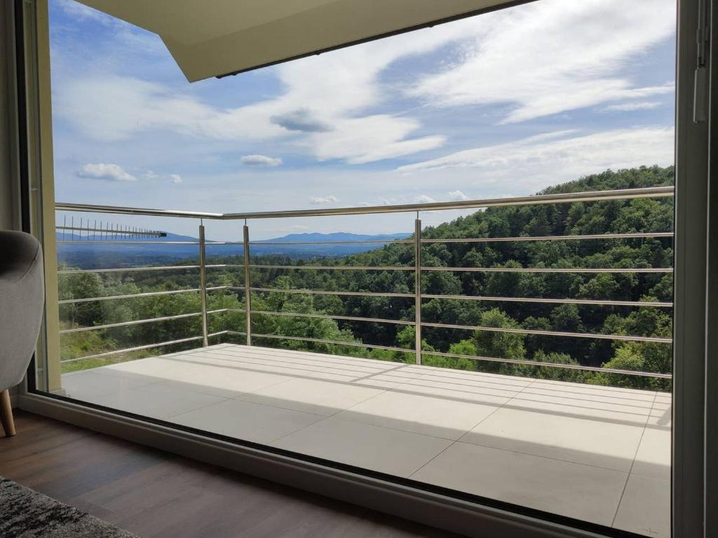 einen Balkon mit einem großen Fenster mit Blick auf eine Brücke in der Unterkunft Hillhouse Novo mesto in Novo Mesto