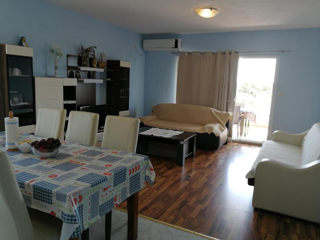 een eetkamer en woonkamer met een tafel en stoelen bij Apartments N&M in Sukošan