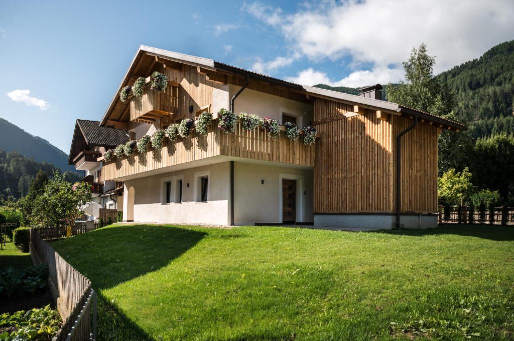 ein Haus mit großem Rasen davor in der Unterkunft Chalet Dolomit in St. Lorenzen