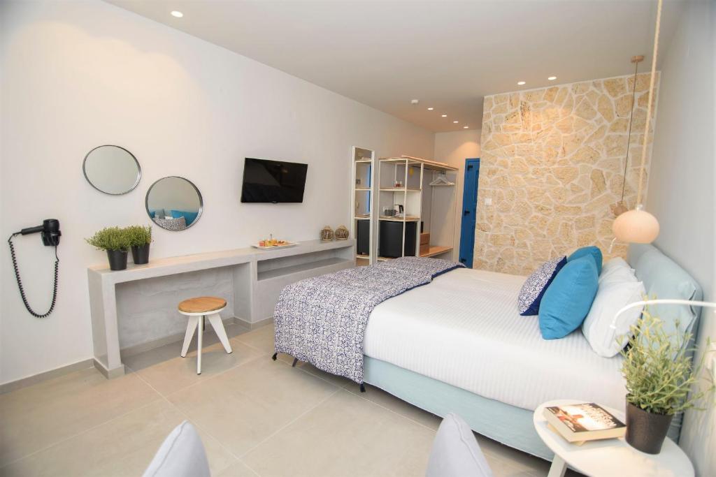 a bedroom with a bed and a desk and a tv at Vigla Hotel in Aegiali