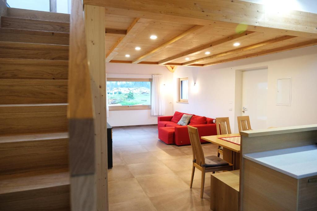 a living room with a red couch and a table at Alpine Home Fiemme in Predazzo