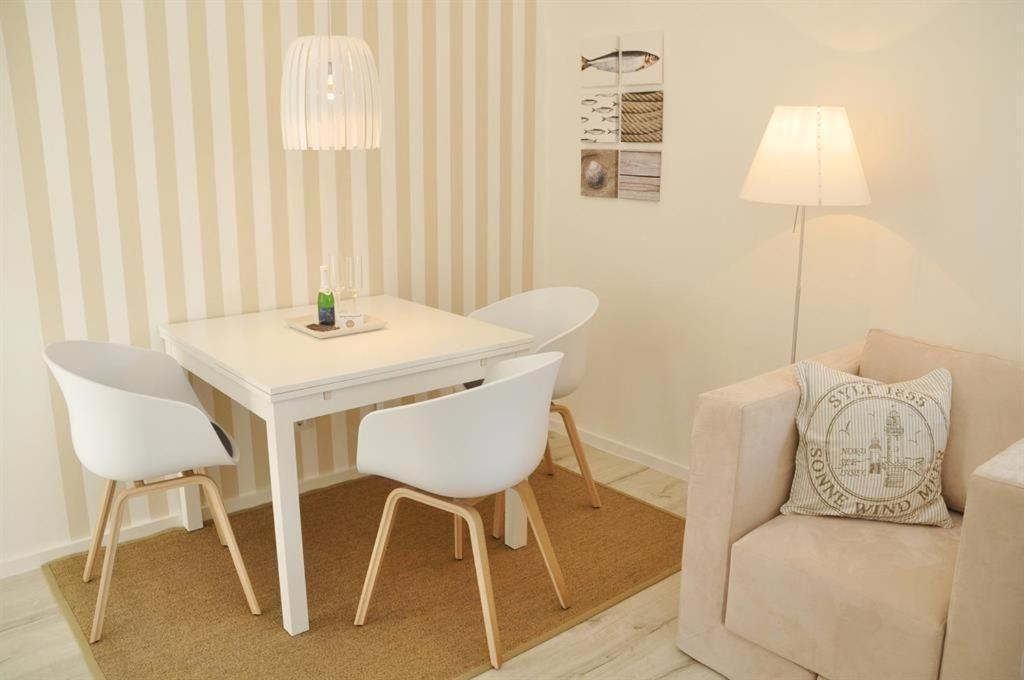 ヴェスターラントにあるHaus-LIV-Appartement-Sandのリビングルーム(テーブル、椅子、ソファ付)