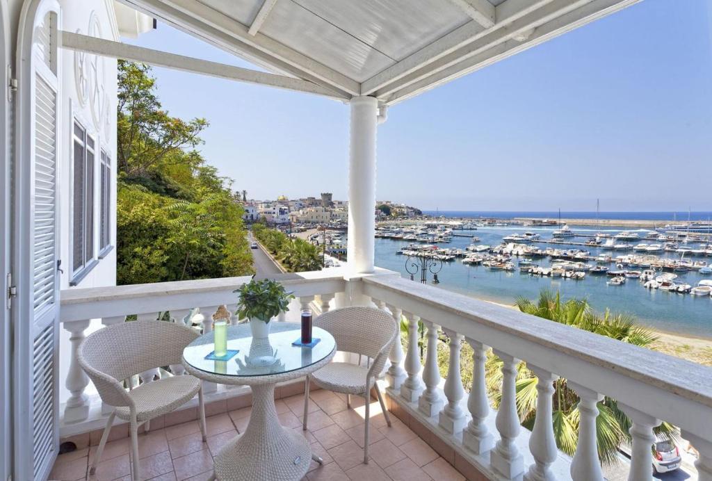 a balcony with a table and chairs and a view of the harbor at Casa Vacanze Parco Del Generale in Ischia