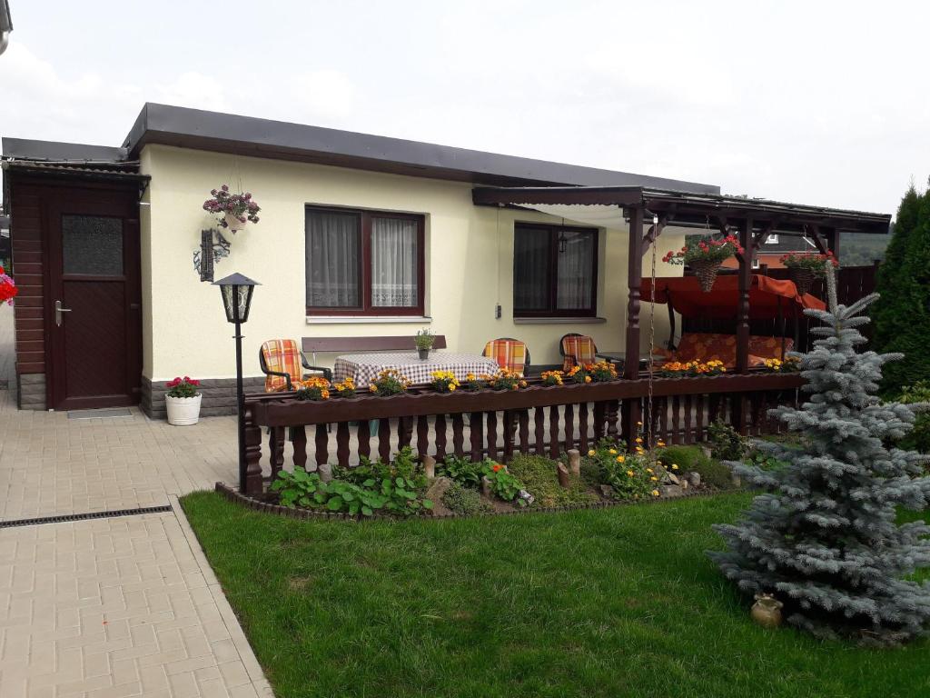 ein Haus mit einem Zaun und einem Tisch im Hof in der Unterkunft Ferienwohnung Ullmann in Ehrenfriedersdorf